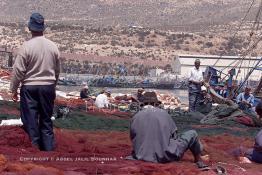 Image du Maroc Professionnelle de  Quelques ouvriers s'activent à réparer les filets de pêche sur un des quais au port d'Agadir, ville située au sud du Maroc, Vendredi 23 Août 2002. (Photo / Abdeljalil Bounhar)

 